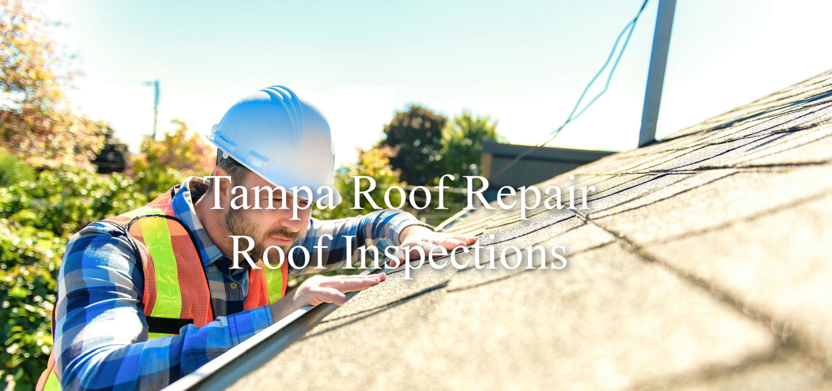 man with hard hat inspecting shingles on roof